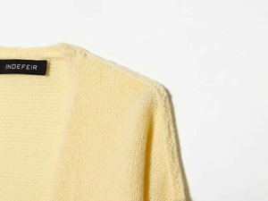 Detail shot of pale yellow chunky knit cardigan featuring high-quality textured stitching