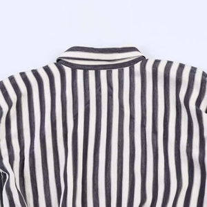 Detail of the back collar and shoulder seams on a black and white striped sleeveless dress