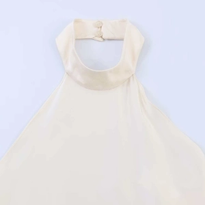 Close-up of halter neck with double-button closure on cream backless top