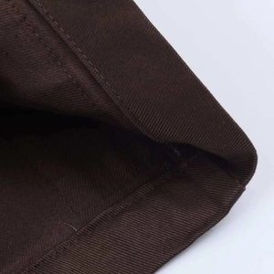 Detailed macro view of dark coffee twill fabric with professional inner edge stitching