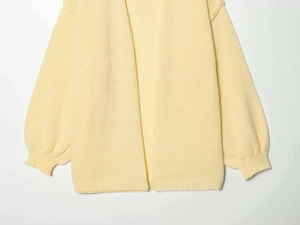 Detailed view of yellow chunky knit cardigan with ribbed cuffs and open front design
