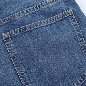 Detail of vintage blue denim balloon jeans showing back pocket stitching and fabric texture