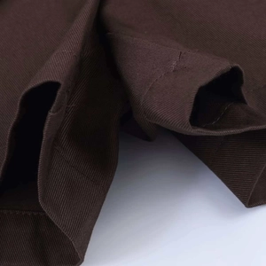Minimalist high-waisted brown skort featuring textured twill fabric and irregular hem detail