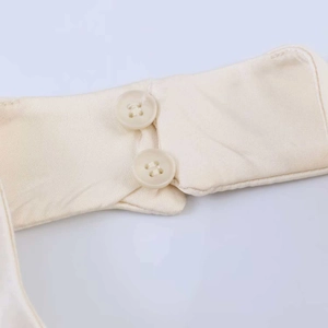 Detail view of the cream satin fabric showing the double button closure and smooth texture