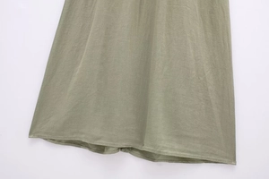 Detailed view of sage green linen blend dress hem with neat stitching and smooth texture