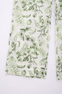 Détail de l'imprimé floral vert sur un pantalon large en lin blanc respirant