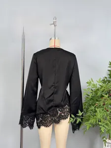 Detail of the back view of a black satin blouse with lace trim and invisible zipper
