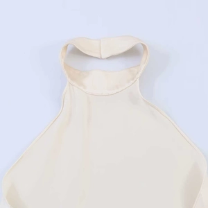 Detail of elegant off-white halter neck top showing refined sewing and stand collar