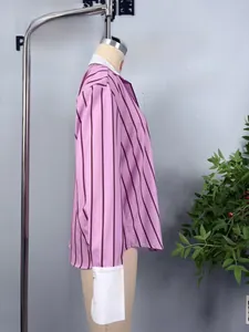 Close-up of pink striped shirt with white contrast cuffs and long sleeves for women