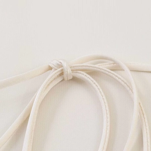 Detail shot of cream halter top fabric texture and knot tying design details