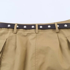 Detail der khakifarbenen Cargo-Rock-Taille mit dunkelbraunem Gürtel und Metallnieten