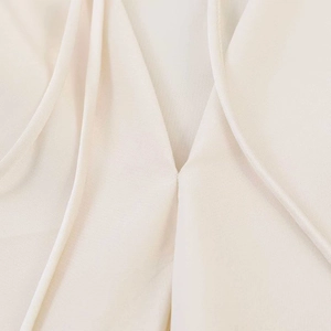 Detail of V-neck stitching and textured cream fabric on this halter backless top