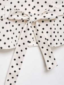 Close-up of beige polka dot blouse waist detail with matching bow-tie fabric belt