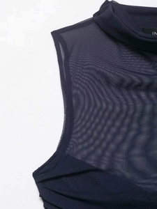 Dettaglio del tessuto a rete semitrasparente e collo a lupetto del top blu navy