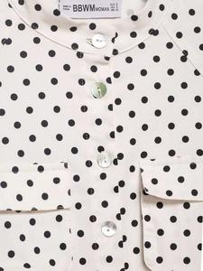 Detailed close-up of polka dot blouse showing button placket and symmetrical flap pockets
