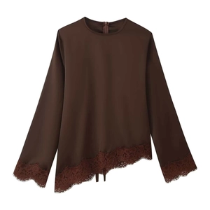 Detail of coffee brown top featuring delicate lace trim and asymmetric hemline
