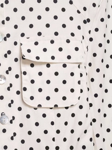 Detail of light beige polka dot shirt with flap pocket and pearl buttons on twill fabric