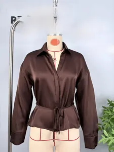 Detail of elegant coffee brown satin shirt with classic lapels and matching waist belt