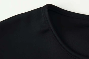 Detailed close-up of a black crew neck top showing high-quality stitching and fabric texture
