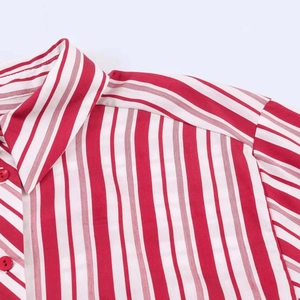 Close-up of red striped shirt collar with glossy red buttons and clean stitching