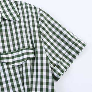 Close-up of green checkered shirt collar and sleeves with a woven cotton texture