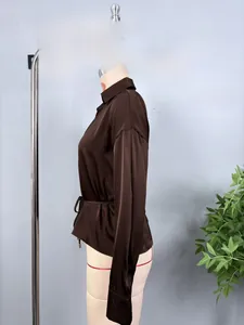 Detail of dark brown satin shirt featuring a collared neckline and waist drawstring