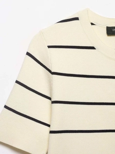 Close-up of beige knit top with black stripes, showing neck detail and fabric texture