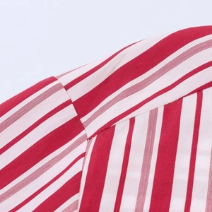 Detail view of red and white striped shirt fabric with high-quality stitching and texture