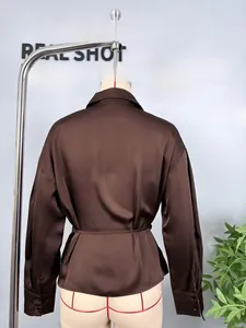 Detail view of the back of a brown satin long-sleeve shirt with adjustable waist tie