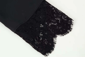 Detailed view of black chiffon top featuring delicate floral eyelash lace trim hem