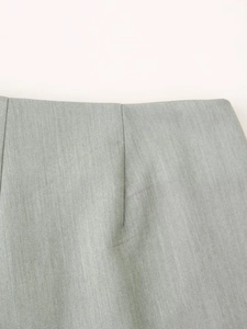 Detail of waist stitching and twill fabric texture on high-waist sage green shorts