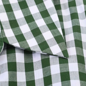 Detailed macro view of the green gingham cotton fabric and stitching on a shirt collar