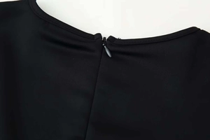 Detail of invisible teardrop zipper on back neckline of black round neck chiffon blouse