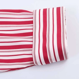 Macro shot of red and white striped shirt fabric with high-quality rolled cuff stitching