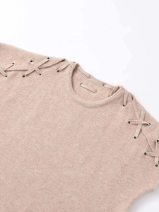 Detail of oatmeal knit top featuring silver grommets and stylish shoulder lace-up design