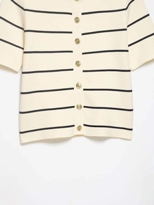 Detail of nautical gold anchor buttons on a beige striped knitted cardigan sweater