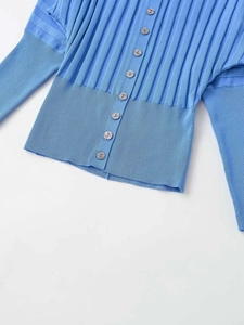 Detail of light blue knit cardigan featuring accordion sleeves and textured ribbing
