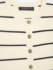 Detail of nautical gold anchor buttons on beige knit cardigan with black stripes