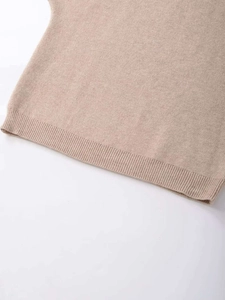 Macro detail of the oatmeal ribbed knit hem showing fine stitching and soft texture