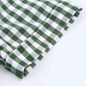 Detail of green and white gingham fabric with a focus on the soft texture and weave