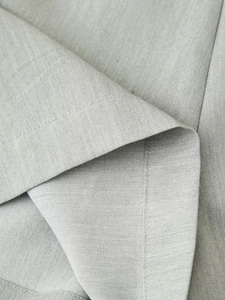 Detail view of premium sage green fabric with high-quality stitching on the summer suit