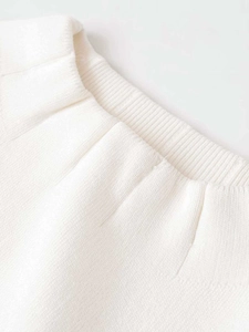 Close-up of premium white knit fabric showing detailed ribbed neckline and texture