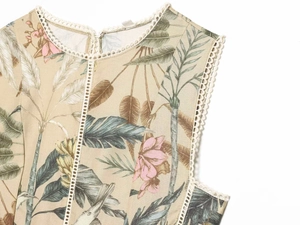 Detailed view of summer dress neckline with tropical print and white lace trim decoration