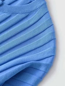 Detail of light blue knitted top showing textured accordion ribbing and ribbed neckline