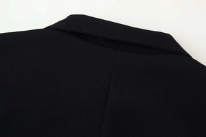 Detail of black stand-collar jacket showing high-quality fabric texture and collar stitching