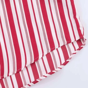 Detail of red and white striped shirt fabric with fine stitching and curved hemline