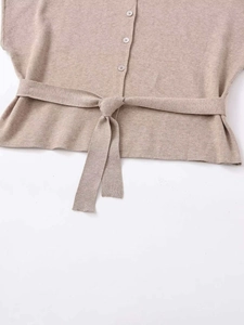 Macro detail of oatmeal knit cardigan showing texture, buttons and tie-waist