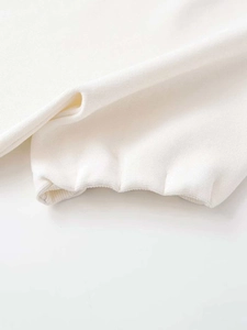 Close-up of premium white knit fabric texture and elastic ribbed cuff detail