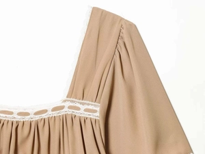 Détail de l'encolure carrée avec bordure en dentelle blanche et tissu froncé couleur kaki