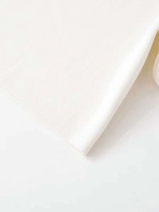Detailed macro view of the premium cream white knit fabric texture and refined stitching
